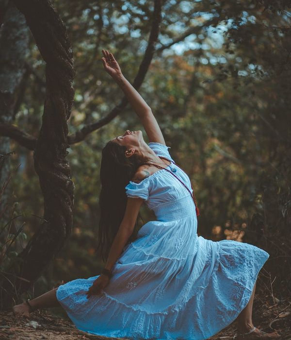 Woman performing a graceful yoga pose in a serene blue and amber light setting.